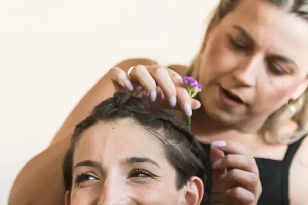 Backstage: a dancer laughs as another puts flowers in her hair