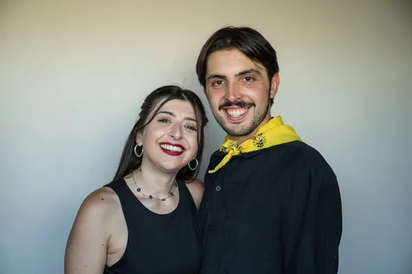 Two dancers arm in arm, he with a yellow scarf round his neck