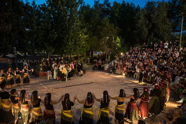 The circle of dancers in yellow scarves in front of the full stands