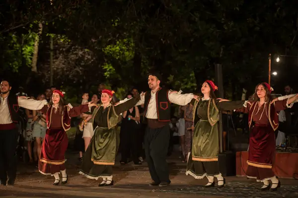Dancers in traditional dress dancing with arms spread